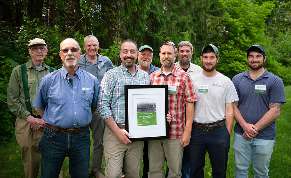 Representatives of New England Forestry Consultants hold their organization's award