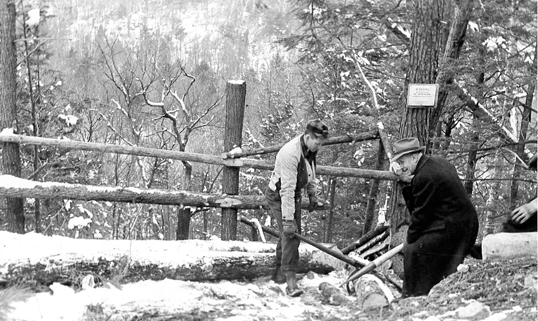 NEFF forester Milt Attridge and NEFF founder Harris Reynolds start a log down a log chute to the valley below.
