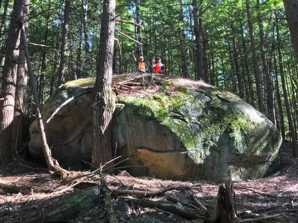 Elizabeth Gillette (left) and NEFF Stewardship Manager Beth Gula (right) atop a large glacial erratic at Thissell-Smith Memorial Forest. Photo taken by Jay Kenty during a 2019 conservation easement monitoring visit.